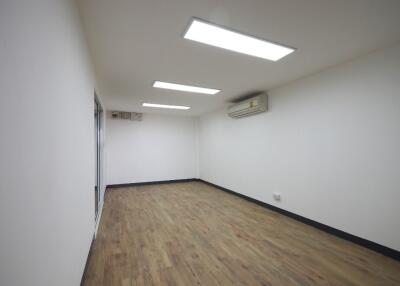 Empty room with wooden flooring and ceiling lights