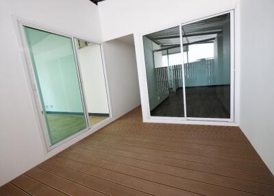 Modern balcony with wooden flooring and large glass doors