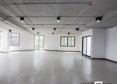 Spacious empty room with large windows and concrete ceiling