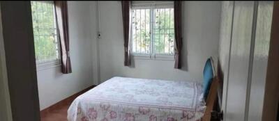 Well-lit bedroom with large windows and a double bed