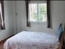 Well-lit bedroom with large windows and a double bed