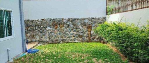 Backyard with grass and stone wall