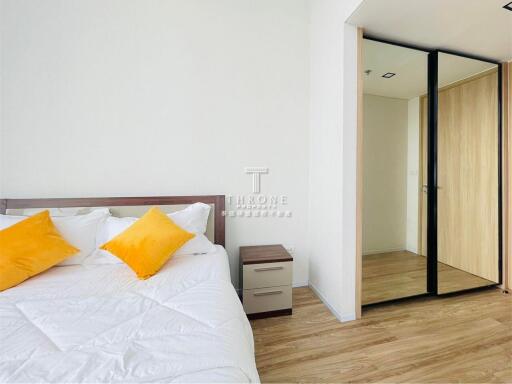 Modern bedroom with hardwood flooring and mirrored closet