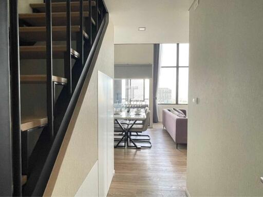 Living area with staircase, dining table, and sofa