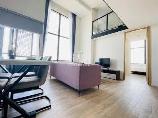 Modern living room with balcony, large windows, and stylish furniture