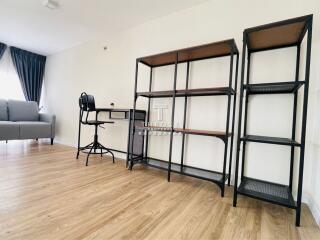 Spacious living room with sofa, desk, and shelving unit