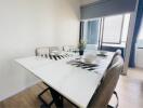 Modern dining area with white table and upholstered chairs