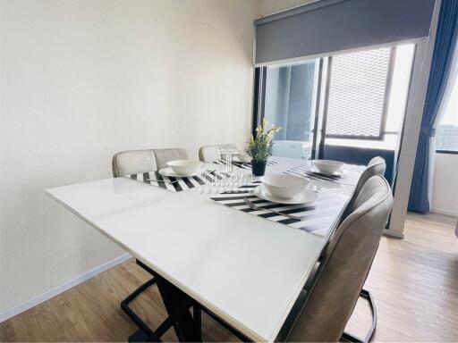 Modern dining area with white table and upholstered chairs