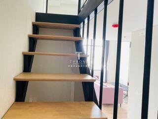 Modern living area with wooden stairs and natural lighting