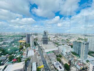 Aerial view of a cityscape with multiple tall buildings and a clear blue sky.