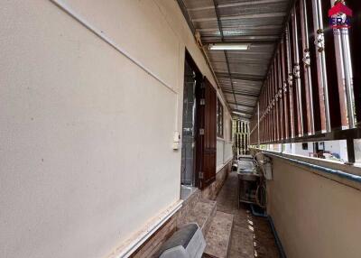 Side corridor with steps, wooden door, and utility area