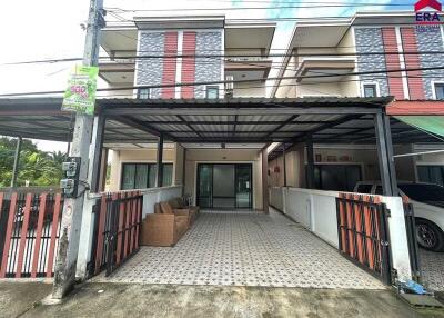 Exterior view of a residential townhouse with a covered driveway