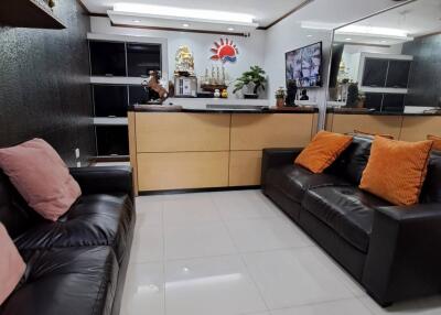 Modern living room with black leather sofas and decorative cushions