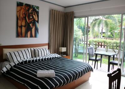 Spacious bedroom with a king-sized bed, artwork, sliding doors to patio