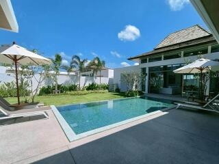 Modern backyard with a swimming pool and lounge chairs