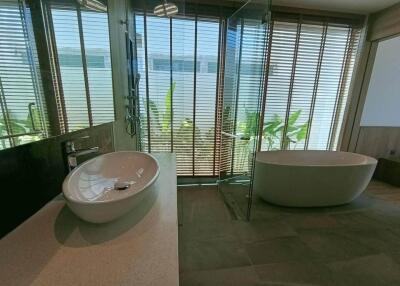 Modern bathroom with large windows, bathtub, and glass shower