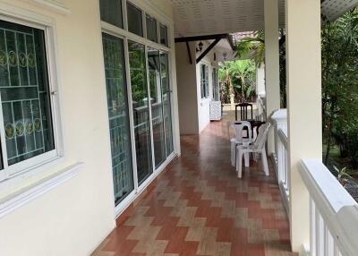 Covered outdoor patio with tiled flooring and seating area