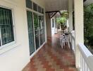 Covered outdoor patio with tiled flooring and seating area