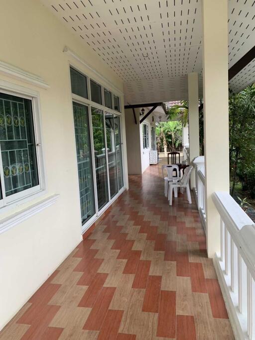 Covered outdoor patio with tiled flooring and seating area