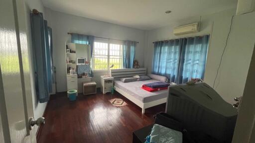 Cozy bedroom with wooden flooring and blue curtains