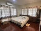 Spacious bedroom with large windows and hardwood floor