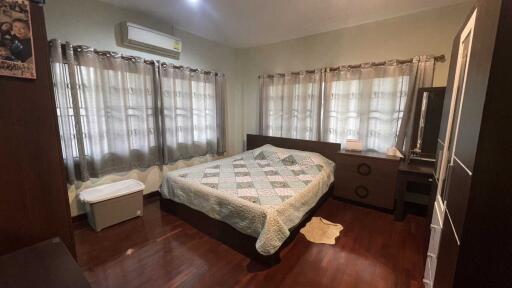 Spacious bedroom with large windows and hardwood floor