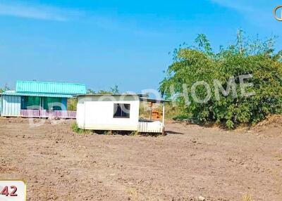 Vacant land with a small structure and some sparse vegetation