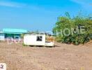 Vacant land with a small structure and some sparse vegetation