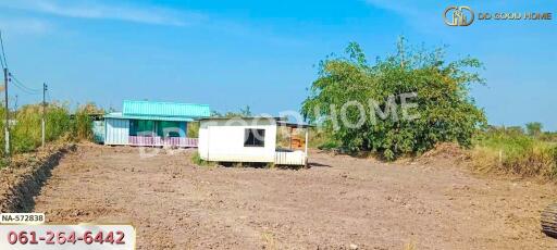 Vacant land with a small structure and some sparse vegetation