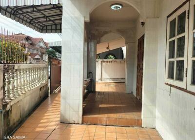 Covered outdoor hallway with tiled floor and arched ceiling