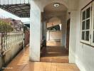 Covered outdoor hallway with tiled floor and arched ceiling