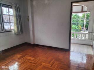 Empty bedroom with wooden flooring and a balcony