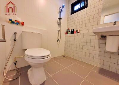 Bathroom with toilet, shower, and sink.