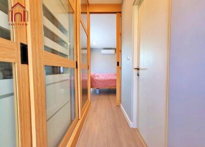 Bright hallway with sliding wooden doors leading to a bedroom