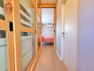 Bright hallway with sliding wooden doors leading to a bedroom