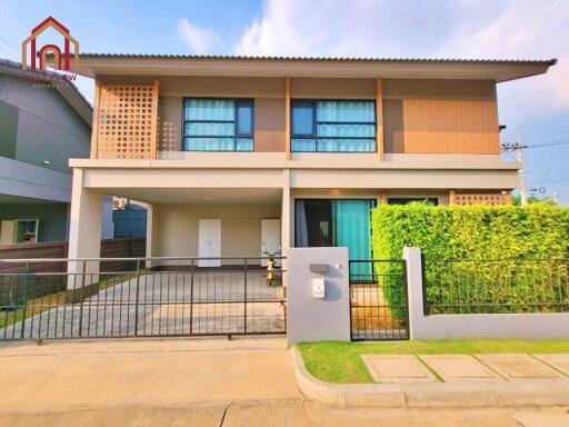 Front view of a modern two-story house with a driveway and a well-maintained lawn.