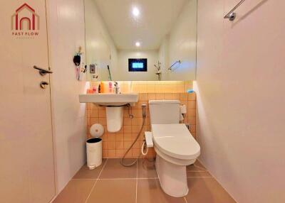 Modern bathroom with toilet, sink, and large mirror