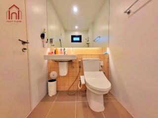 Modern bathroom with toilet, sink, and large mirror