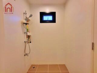 Shower area with tiled floor and small window