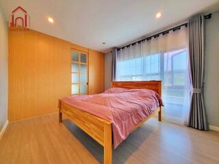 Spacious bedroom with wooden bed and large windows