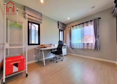 Spacious home office with desk, chair, and large windows