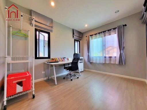 Spacious home office with desk, chair, and large windows