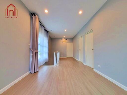 spacious main living area with wooden floors and large windows