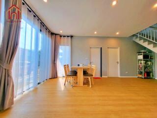 Spacious living area with dining table and large windows