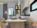 Modern kitchen with dining area, stylish lighting, and contemporary decor