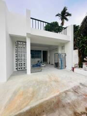 Front view of a modern two-story home with white exterior walls and a balcony