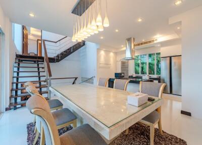 Modern kitchen and dining area with stairs and large windows