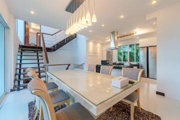 Modern kitchen and dining area with stairs and large windows