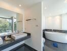 Modern bathroom with double sinks, large mirror, and freestanding bathtub