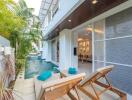 Modern outdoor pool area with loungers and a view into the living space